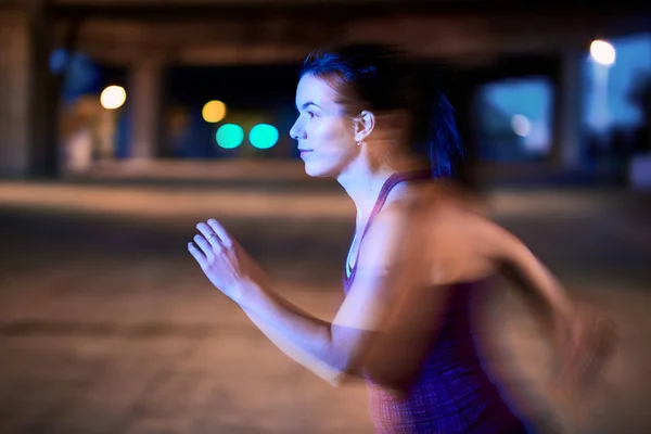 Atractiva mujer milenaria manteniéndose en forma al correr al aire libre en un entorno urbano —  Fotos de Stock