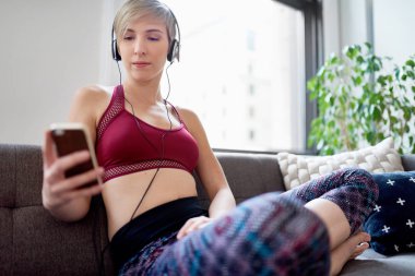 Trendy kadın onu mindfulness sabah rutin bir parçası olarak bir meditasyona app için dinleme
