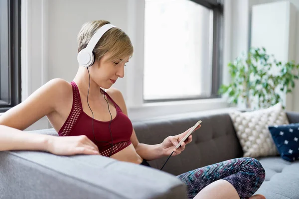 Trendy kadın onu mindfulness sabah rutin bir parçası olarak bir meditasyona app için dinleme