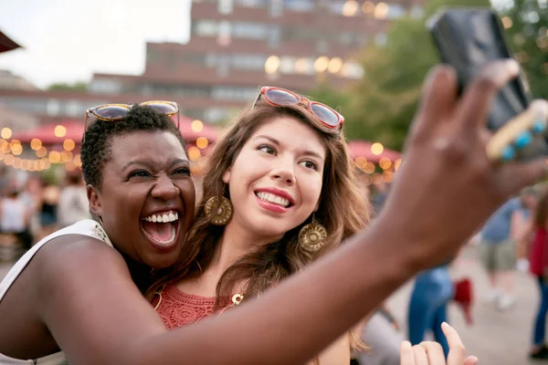 Grupo diverso de duas meninas tirando fotos selfies na multidão de um festival de música de verão — Fotografia de Stock