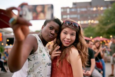 İki kız bir yaz Müzik Festivali kalabalıkta selfies fotoğraf çekmek çeşitli grup