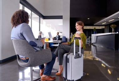 İki farklı modaya uygun iş adamı buluşuyor ve konuşuyorlar.