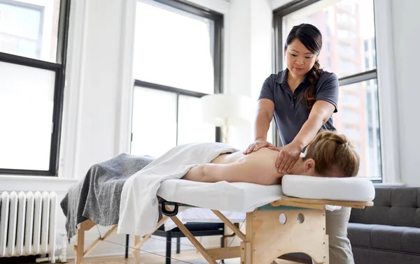 Chinesische Frau Massage-Therapeutin gibt einer Attraktion eine Behandlung — Stockfoto