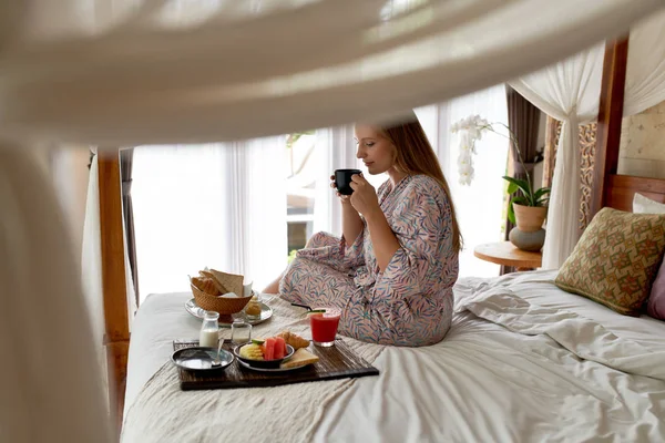 Fiatal nő fényes szállodai szobában eszik egészséges vegetáriánus szünet — Stock Fotó