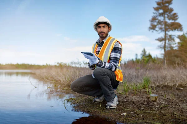 Biólogo marino analizando los resultados de la prueba de agua en una tableta en Can Imagen De Stock