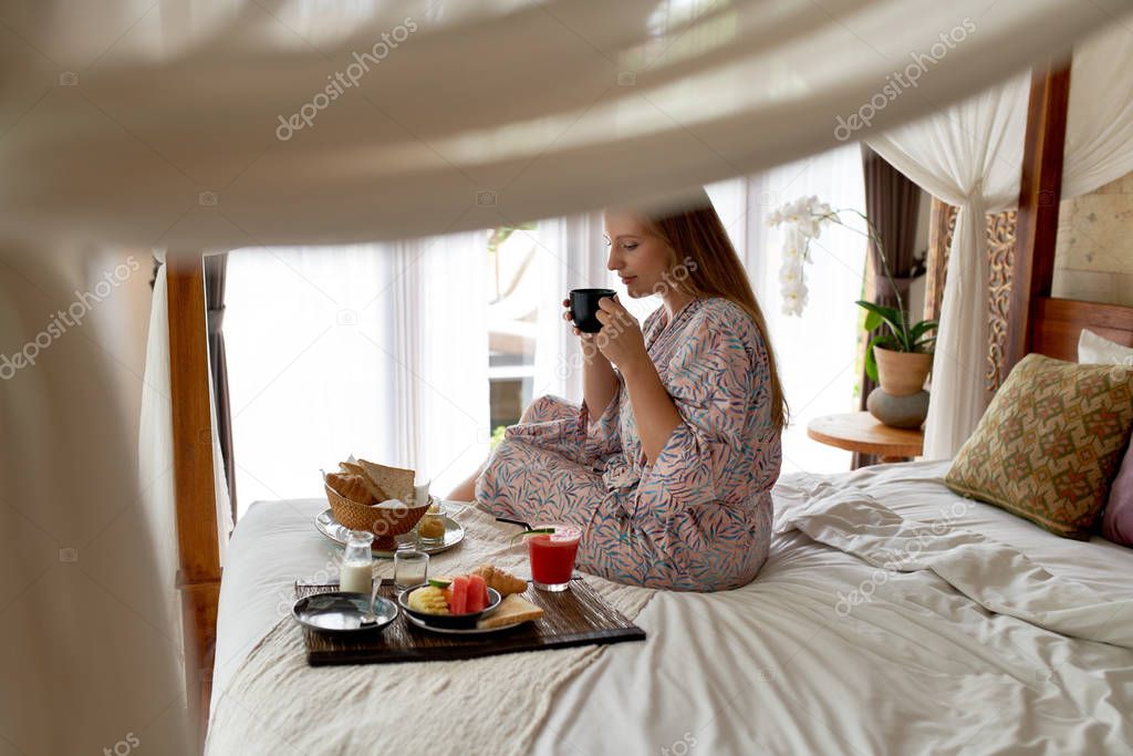 Young woman in bright hotel room eating healthy vegetarian break