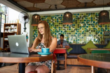 Bin yıllık güzel bir kadın dizüstü bilgisayarda yazı yazıyor.