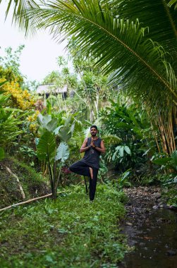 Endonezya 'da yoga ve rahatlama pratiği yapan sağlıklı genç bir adam.