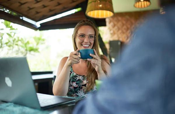 Giovane donna millenaria in possesso di tazza di caffè sorridente ad un amico duri — Foto Stock