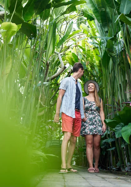 Giovane coppia felice hipster a piedi attraverso la pianta tropicale passag — Foto Stock