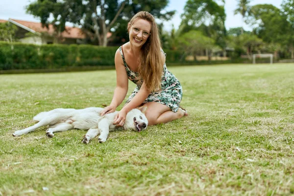 Mladý, krásný blondýnka dívka hrát venku s přátelský pupp Stock Fotografie