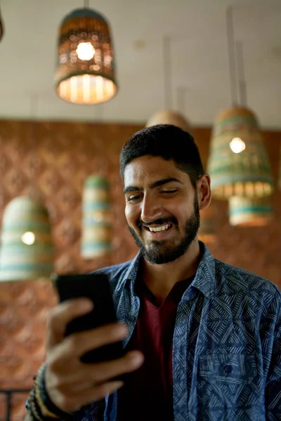 Bello uomo millenario con barba utilizzando smartphone per video ca Immagine Stock