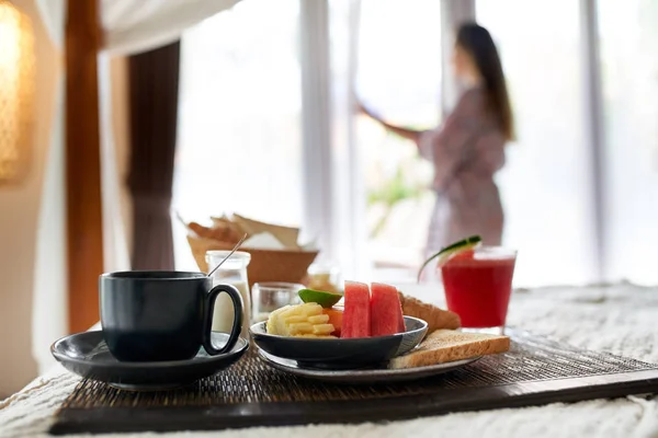 Moderno desayuno vegano y capuchino en la cama del hotel con hembra o Imágenes De Stock Sin Royalties Gratis