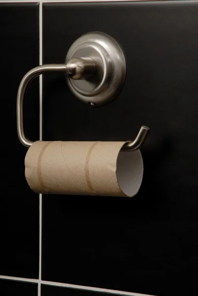 Buis is aan metalen houder, wc-papier is in zwarte badkamer — Stockfoto