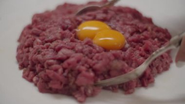 Yavaş çekimde etli tartar pişirin. Dilimlenmiş et ve taze yumurta, çatalla karıştırılmış.. 