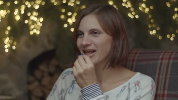 Close-up van glimlachende jonge vrouw het nemen van pillen en drinkwater uit fles in kerstversiering in slow motion. — Stockvideo