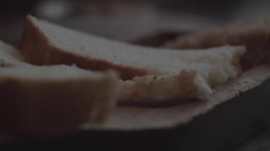 Parlak ekmek dilimlerinin ve ellerin önünde. 