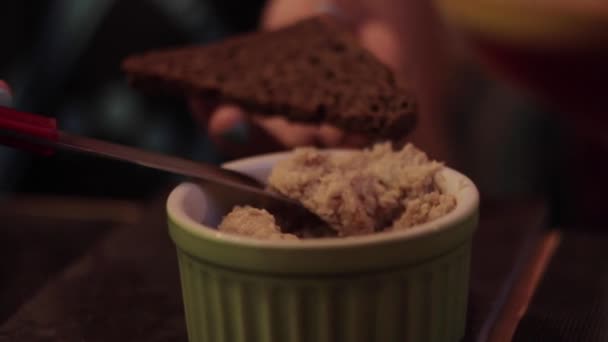 Kawałek chleba z różnymi przystawkami rozprowadzanymi nożem. Samice rozkładają masło na chleb w restauracji. — Wideo stockowe