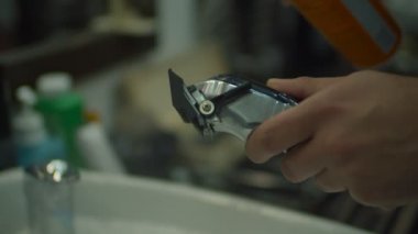 Berberdeki elektrikli tıraş makinesinin kapağı ağır çekimde püskürtülüyor.. 