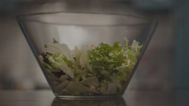 Taze salata cam kaseye yavaş çekimde uçuyor. Salata yapma süreci. 