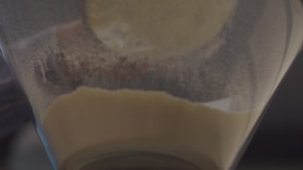 Glutenfritt mjöl som hälls i glasskålen i slow motion. Bottenvy av frisk majs och rismjöl faller ner genom sikten. — Stockvideo