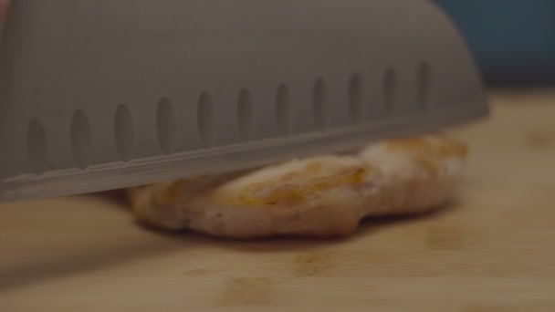 用厨房大刀慢动作地在木制切菜板上切女性手烤鸡肉. — 图库视频影像