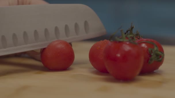 雌性手慢动作地在木制切菜板上用菜刀切西红柿. 船上有三只西红柿. — 图库视频影像