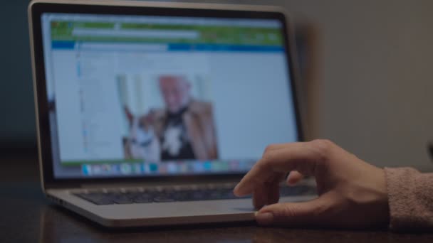 Close-up van vrouwelijke handen scrollen social media pagina 's op laptop met wazig scherm in slow motion. Handen geven likes knop op berichten. — Stockvideo