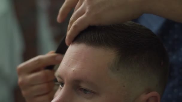 Close up of barbers hands combing mans hair in slow motion. — Stock Video