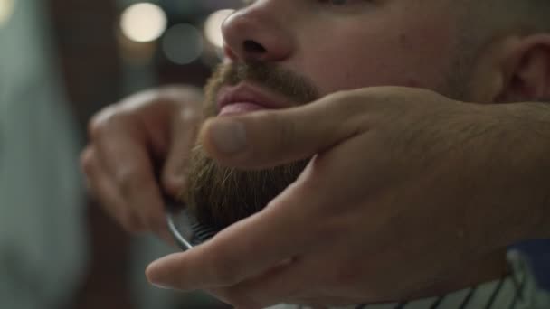 Закрыть руки парикмахеров расчесывая бороду мужчин в замедленной съемке . — стоковое видео