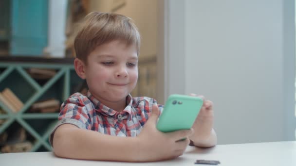 Preschool boy holding smartphone in hands and making picture of card for augmented reality application. Kid likes AR games. — Stock Video