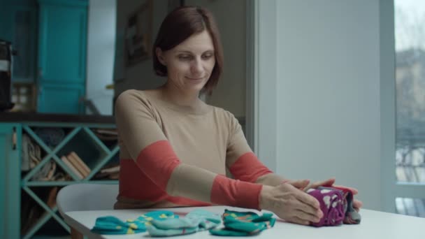 Jeune femme souriante adulte pliant chaussettes de couleur assis à la table. Marie Kondo méthode d'organisation et de simplification de la maison . — Video