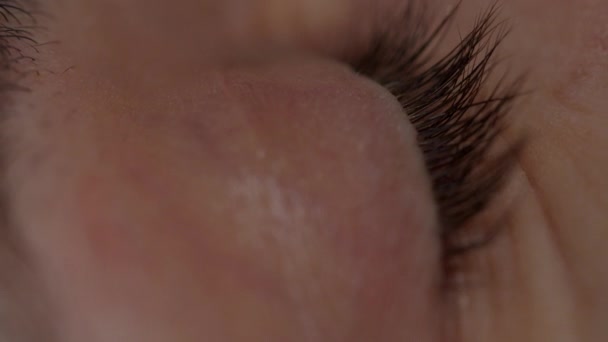 Makro zblízka lidského modrého oka s pohybující se duhovkou. Otevírání a zavírání lidského oka ve zpomaleném pohybu. — Stock video