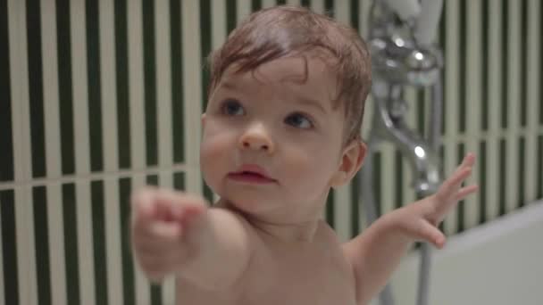 Младенец-блондин принимает ванну с шампунем. Ребенок с мыльными волосами улыбается и играет с мамой . — стоковое видео