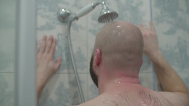 Bald bearded man taking shower by the window in provence bathroom in slow motion. — Stockvideo