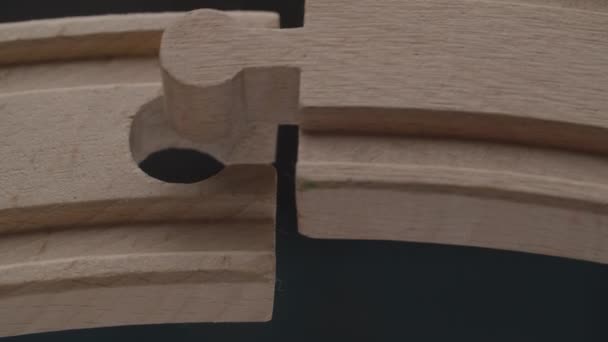 Two peaces of wooden railway constructor perfectly fits each other in macro plan. Wooden puzzle peaces connects. — Stock Video