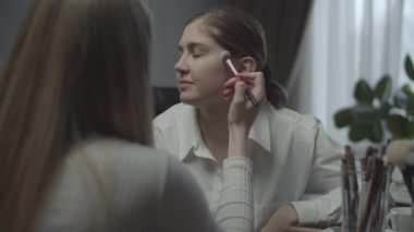 Makyaj için başvuran iki bayan meslektaşım var. İş yerindeki iş kadını için vize başvurusu. Masada bir sürü kozmetik ve fırça var. Kapat.. 