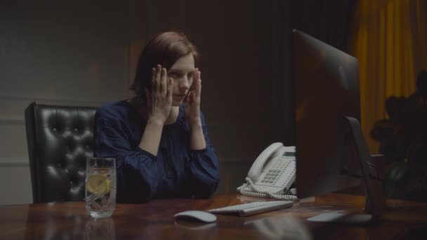 Mladá, vyčerpaná obchodnice pracující v noční kanceláři. Pracující žena trpí migrénou bolesti hlavy, masírování spánků a užívání pilulek s vodou. — Stock video