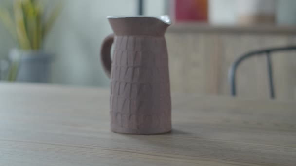 Mãos femininas colocando pote com musgo na mesa de madeira com bule de cerâmica em apartamentos interiores minimalistas . — Vídeo de Stock
