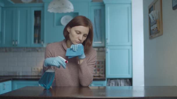 Jovem de 30 anos exausto mulher pulverização detergente e esfregando a superfície da mesa com pano. Mulher perturbada e cansada fazendo casa limpar na cozinha . — Vídeo de Stock