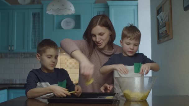 Семья выкладывает картофельные ломтики на капающую сковороду во время приготовления чипсов дома. Счастливая семья вместе на кухне . — стоковое видео