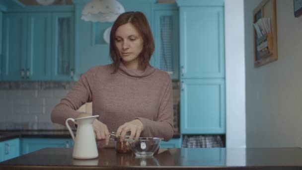 Giovane donna anni 30 prendendo ciotola con riso selvatico e versando acqua dalla brocca nella ciotola con riso. Processo di cottura e routine di cucina . — Video Stock