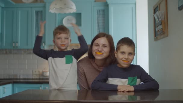 Забавная семья играет с апельсиновой кожурой во рту. Улыбающаяся женщина и дети с апельсиновыми фруктами во рту. Оранжевая улыбка . — стоковое видео