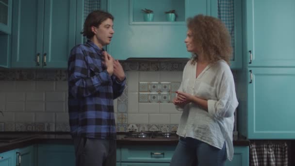 Jovens 20 anos casal brigando em pé na cozinha azul em casa, namorada gritando acusando namorado. Família conflito ciumento . — Vídeo de Stock