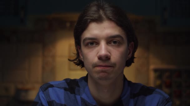 Close up of sad young 20s man portrait looking at camera in dark room in slow motion. Upset male face. — Stock Video