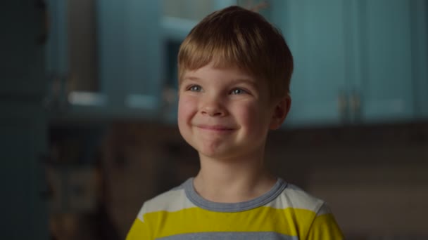 Niño preescolar sosteniendo dos mitades de fruta naranja en las manos, llevándolo a las orejas y sonriendo mirando a la cámara. Orejas de fruta naranja en cámara lenta . — Vídeos de Stock