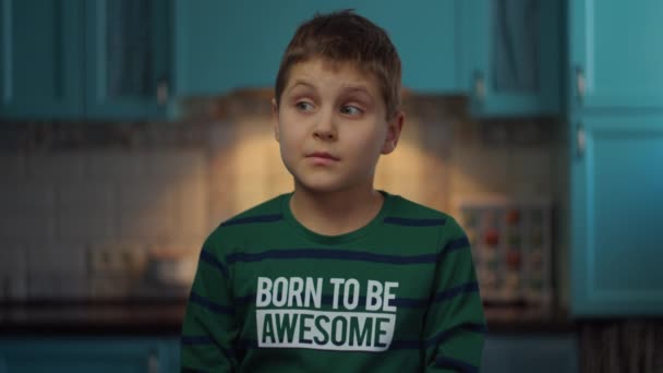 スローモーションでキッチンに立って手でジェスチャーを自閉症の少年。自宅で自閉症の幸せな子供。自閉症の認識 — ストック動画