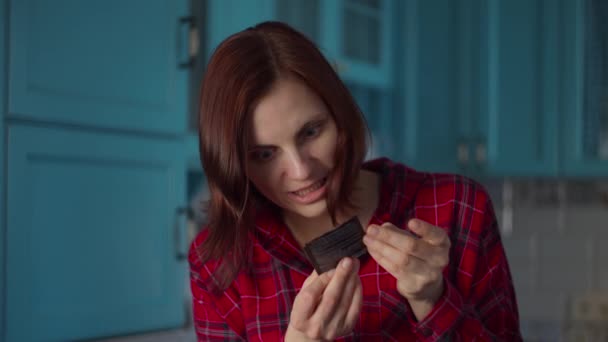 Młoda kobieta po trzydziestce w czerwonej koszuli, czytająca instrukcję maski kosmetycznej na niebieskiej kuchni. Kobieta piękna rutyna w domu. — Wideo stockowe