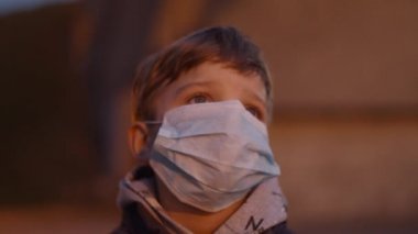 Coronavirus COVID-19 salgını sırasında tıbbi koruyucu maskeli bir çocuğa yakın durun. Kırmızı ışığı olan acil durum sirenleri.. 