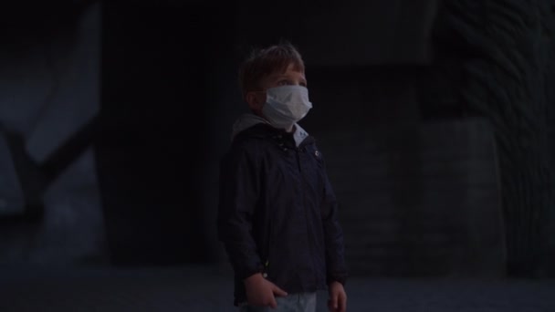 Ragazzo in maschera protettiva medica si trova al riparo durante lo scoppio pandemico di coronavirus COVID-19 e orologi spaventati intorno. Sirena di emergenza con luce rossa all'aperto . — Video Stock